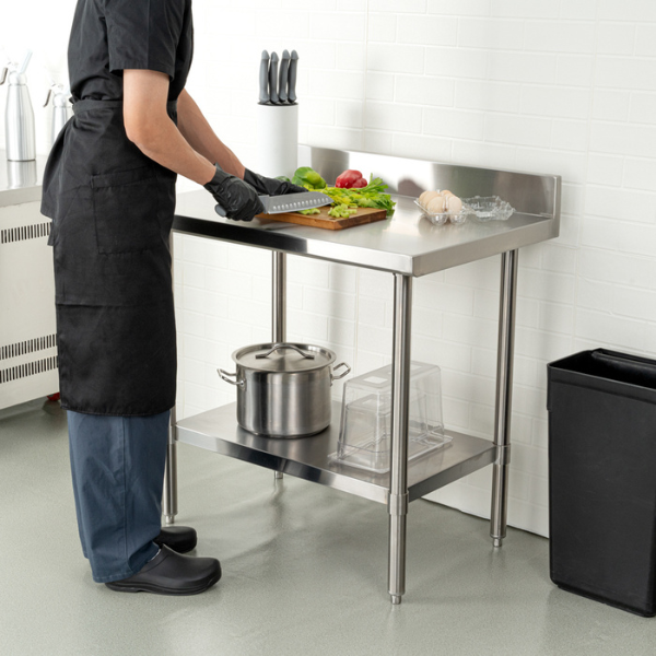 A man is prepping food at a restaurant kitchen.